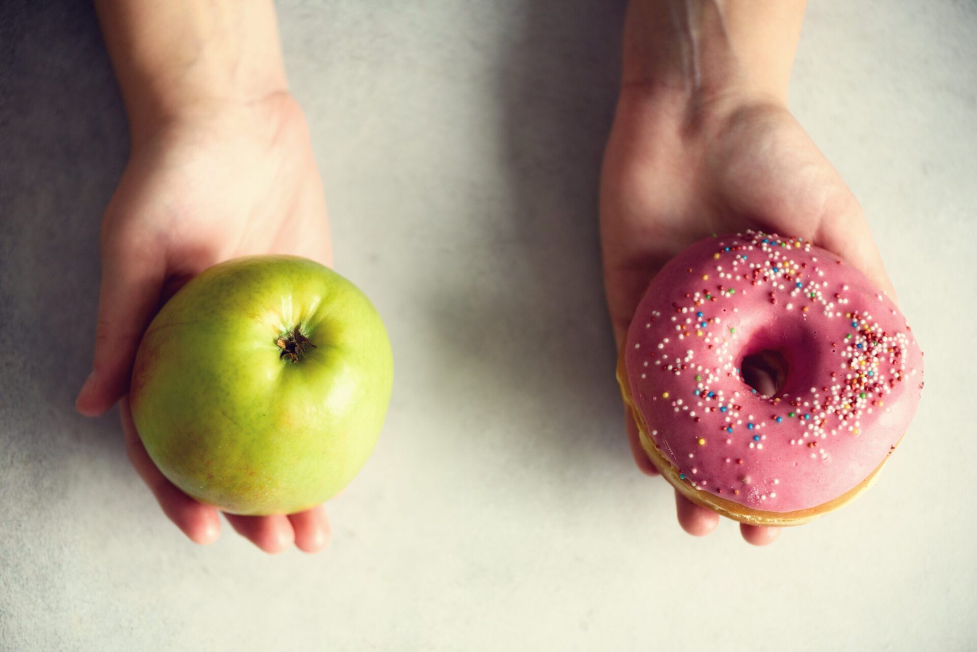 Photo of an apple and a doughnut, representing choices