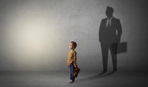 Photo of a little boy imagine that he will be businessman and illustrating his future in a big shadow