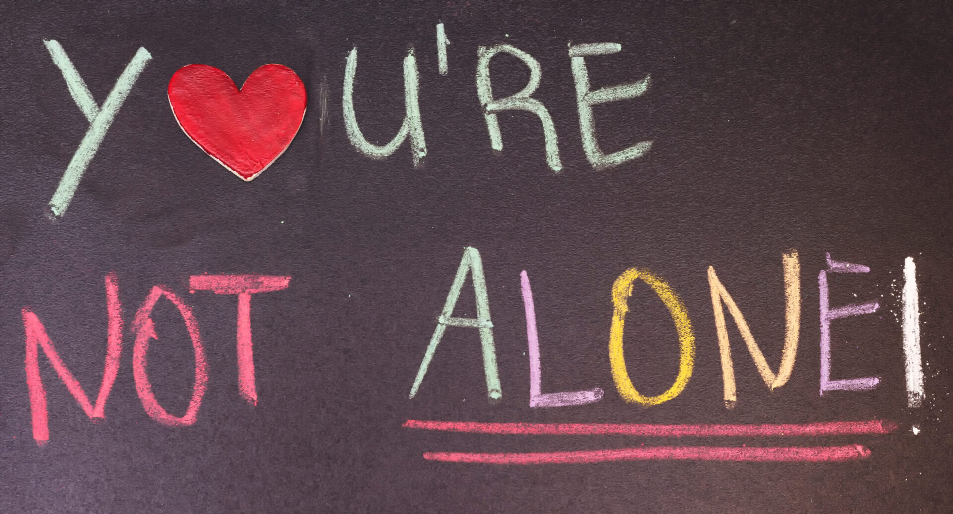 'You're not alone' written on a blackboard