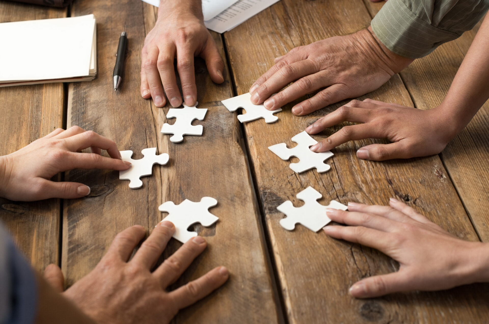 Photo of people putting different puzzle pieces together