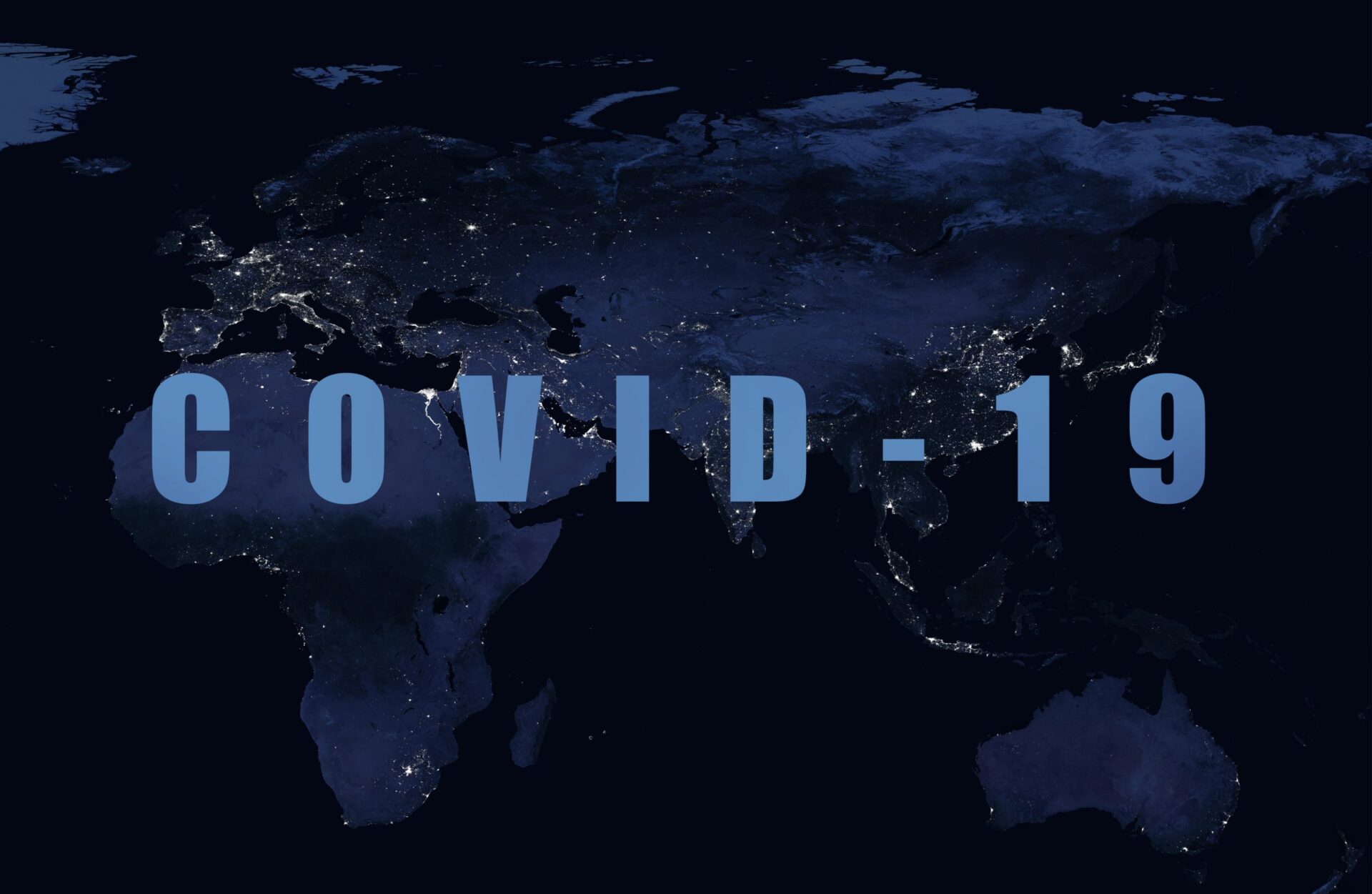 Photo of 'Covid-19' in writing in front of a map of the world