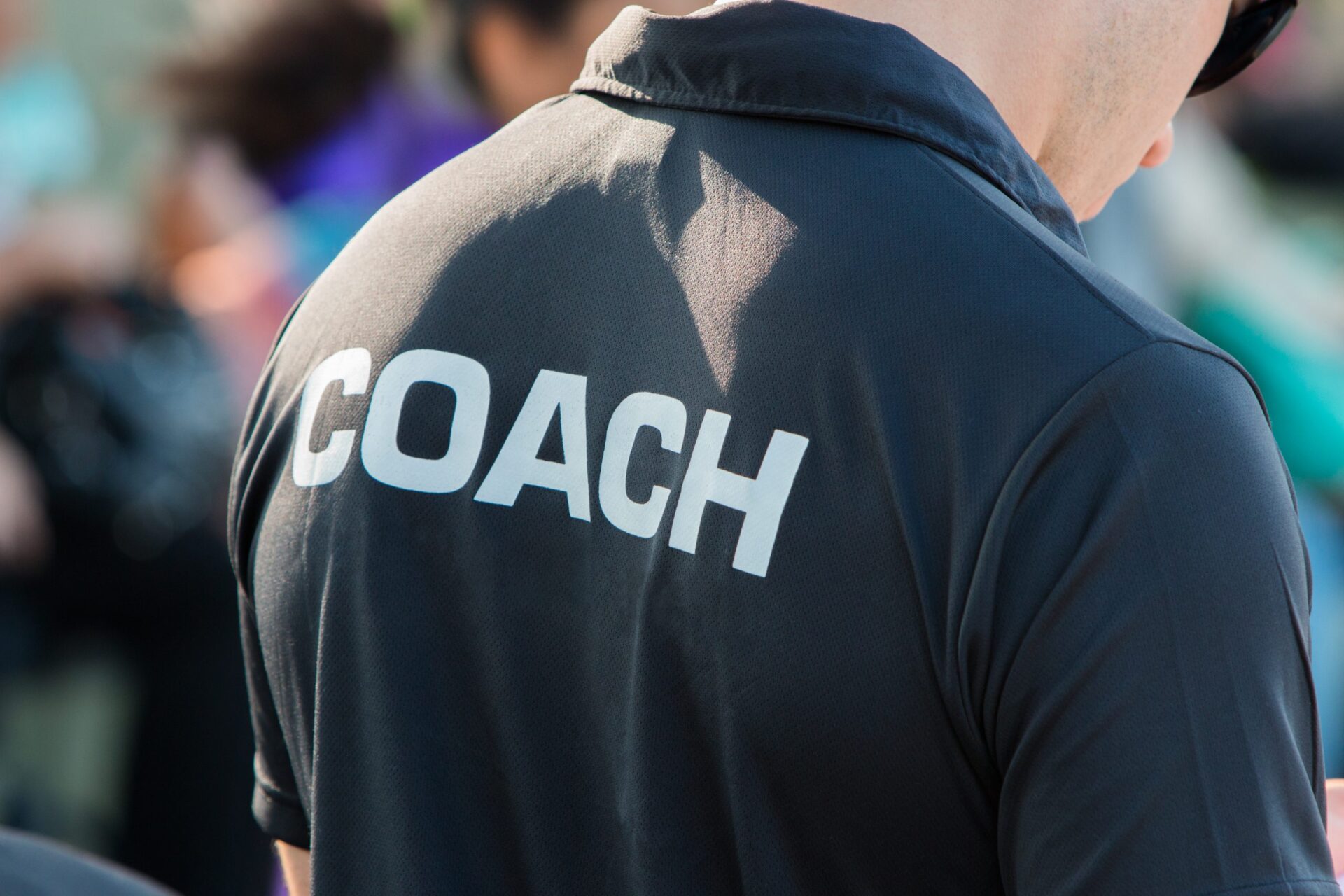 Photo of someone wearing a shirt that says 'coach' on the back