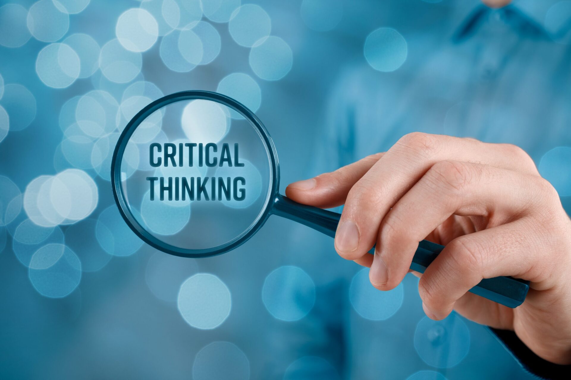 Photo of a magnifying glass over the words 'critical thinking'