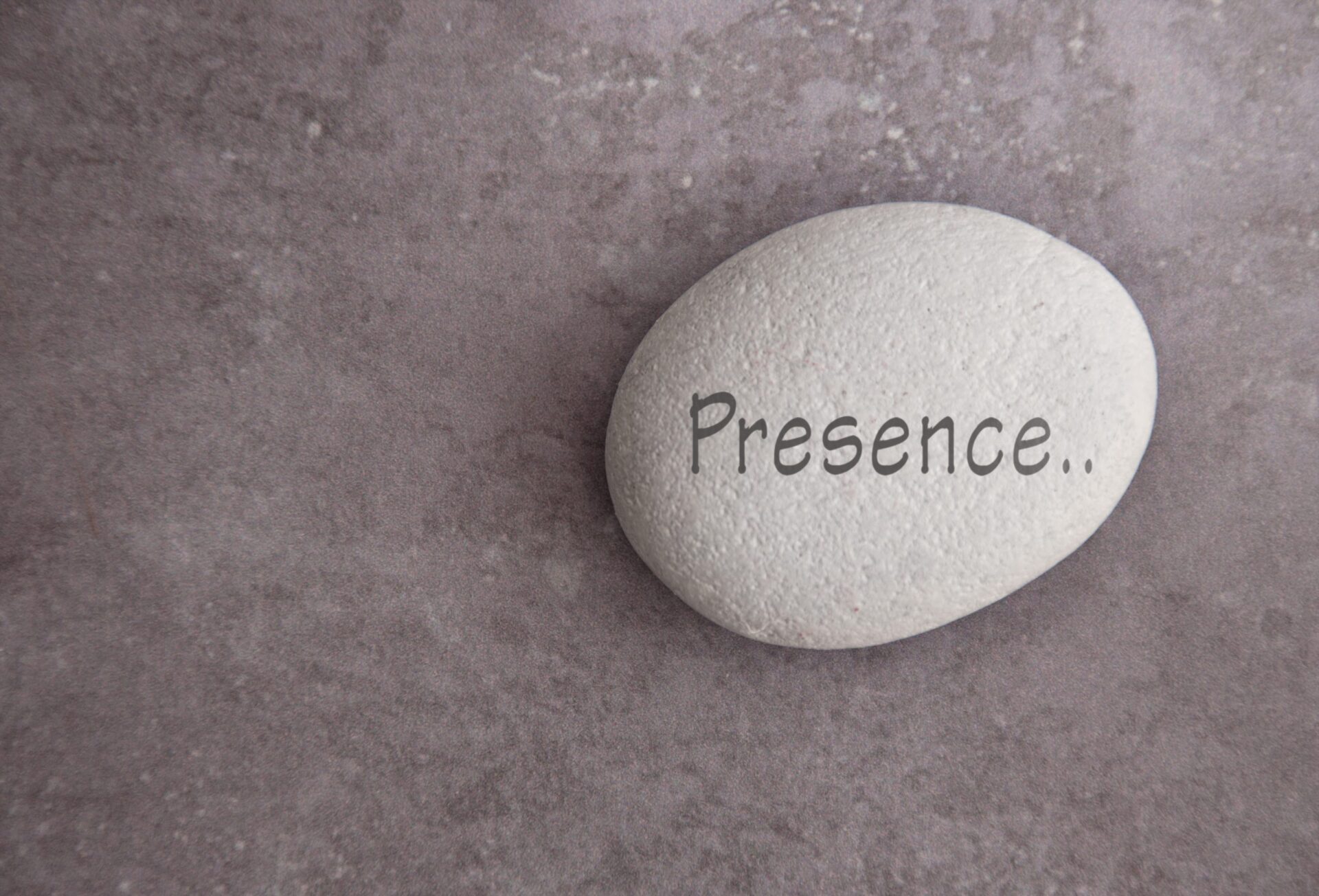Photo of a pebble with the word 'Presence...' written on it