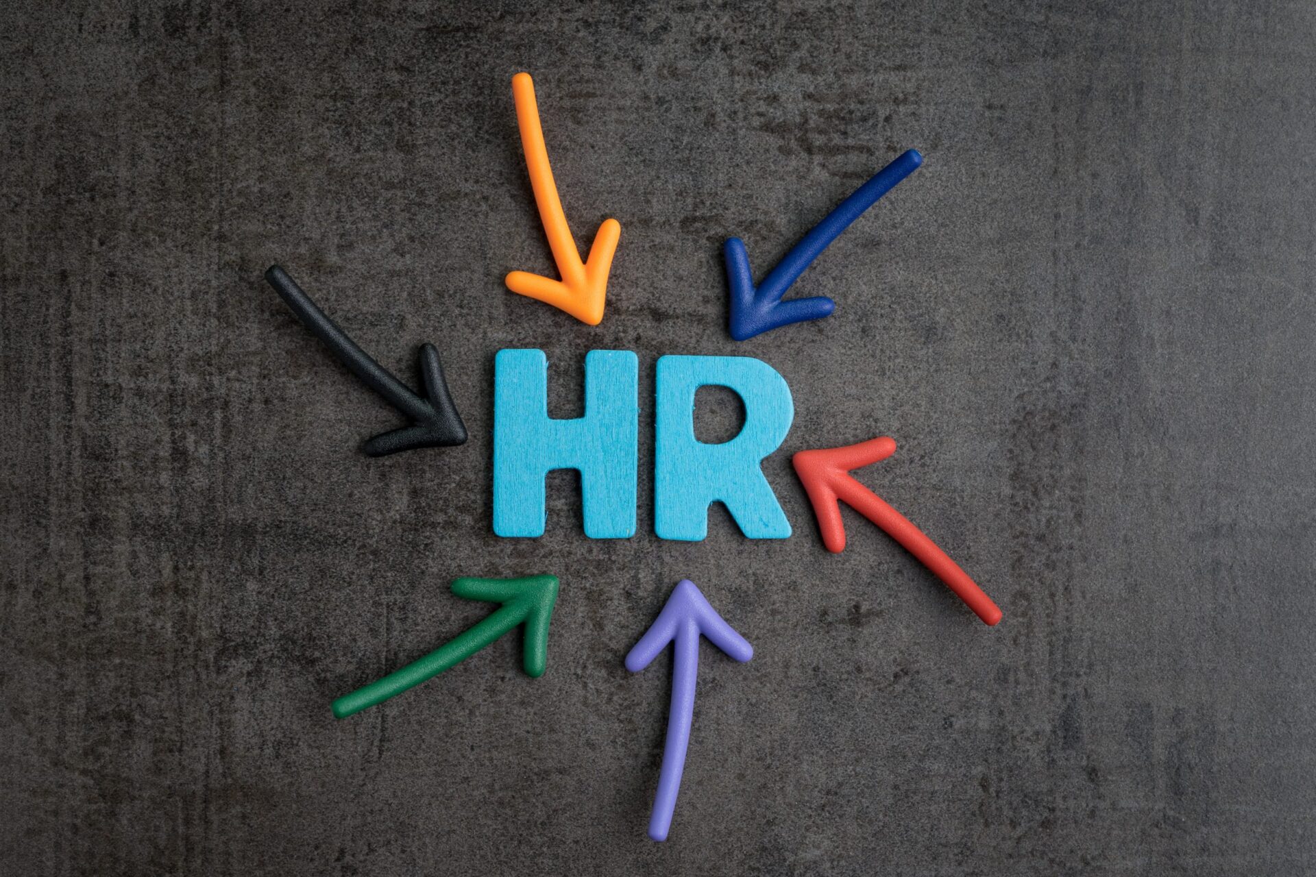 Photo of the word HR surrounded by arrows pointing at it