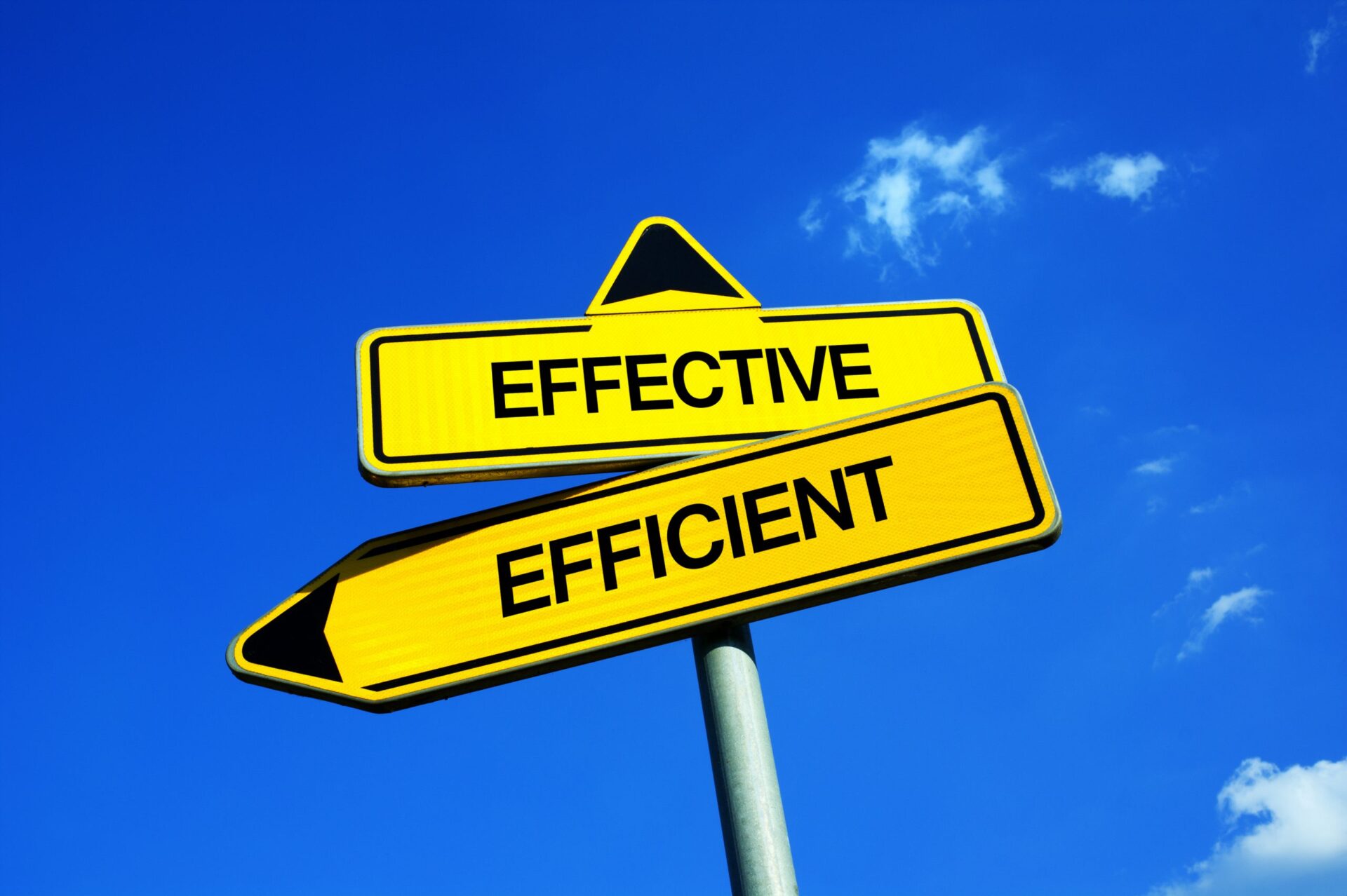 Photo of a sign that says 'Effective' and 'Efficient', pointing in different directions