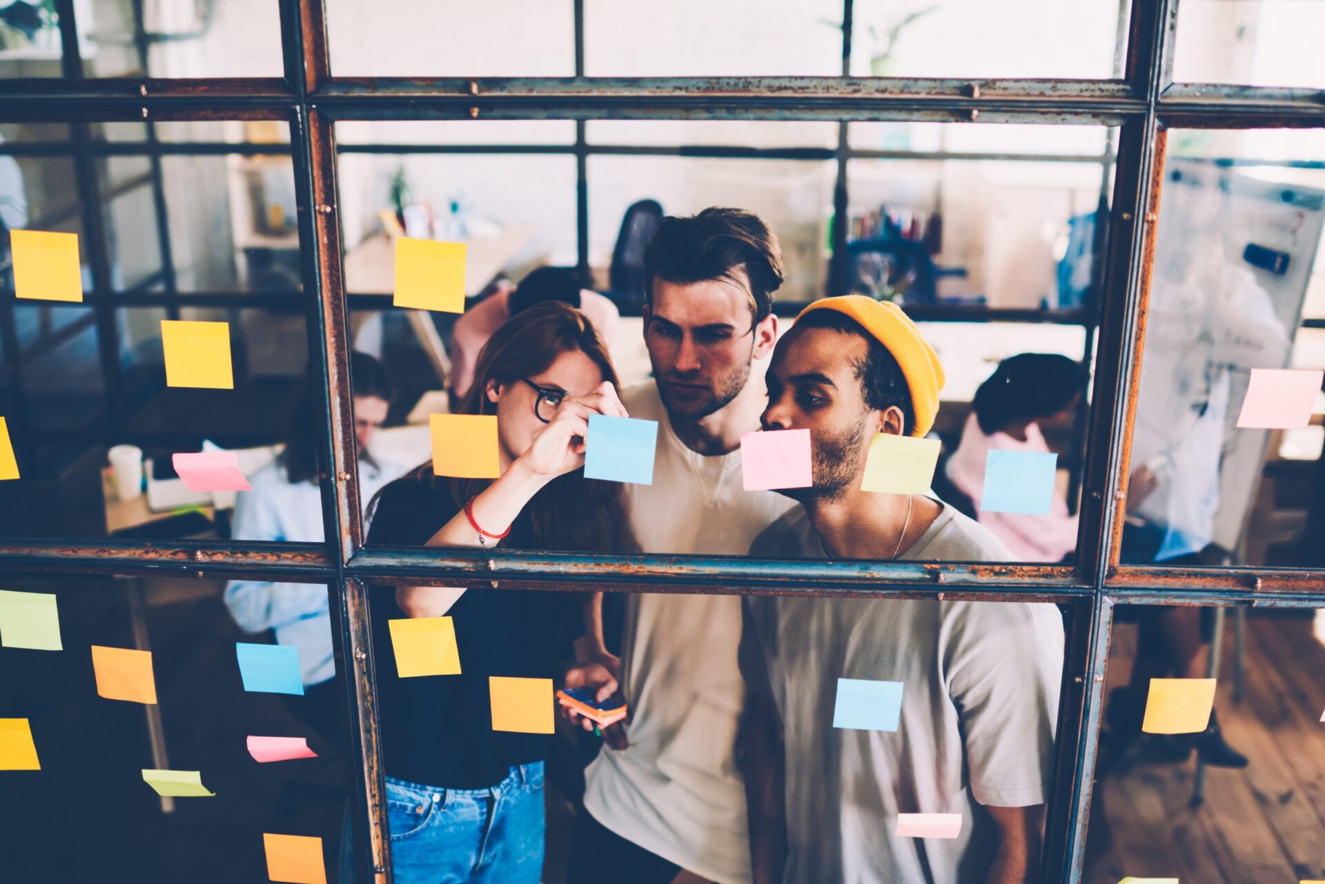 Photo of people looking at post-it notes on a wall