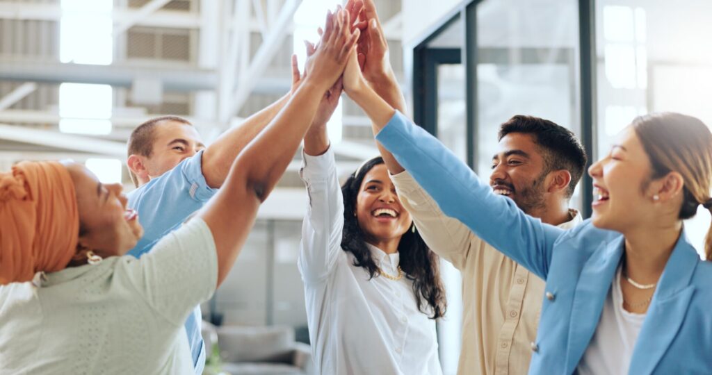 Group of employees happy and high-fiving on another